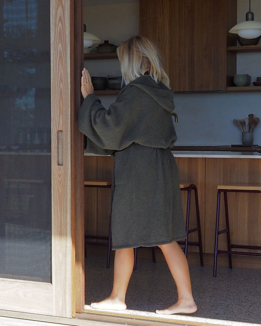 Person wearing the Banksia knitted home robe in a kitchen doorway