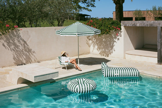 Striped inflatable pool lounger and pool ring in a sunny Australian pool
