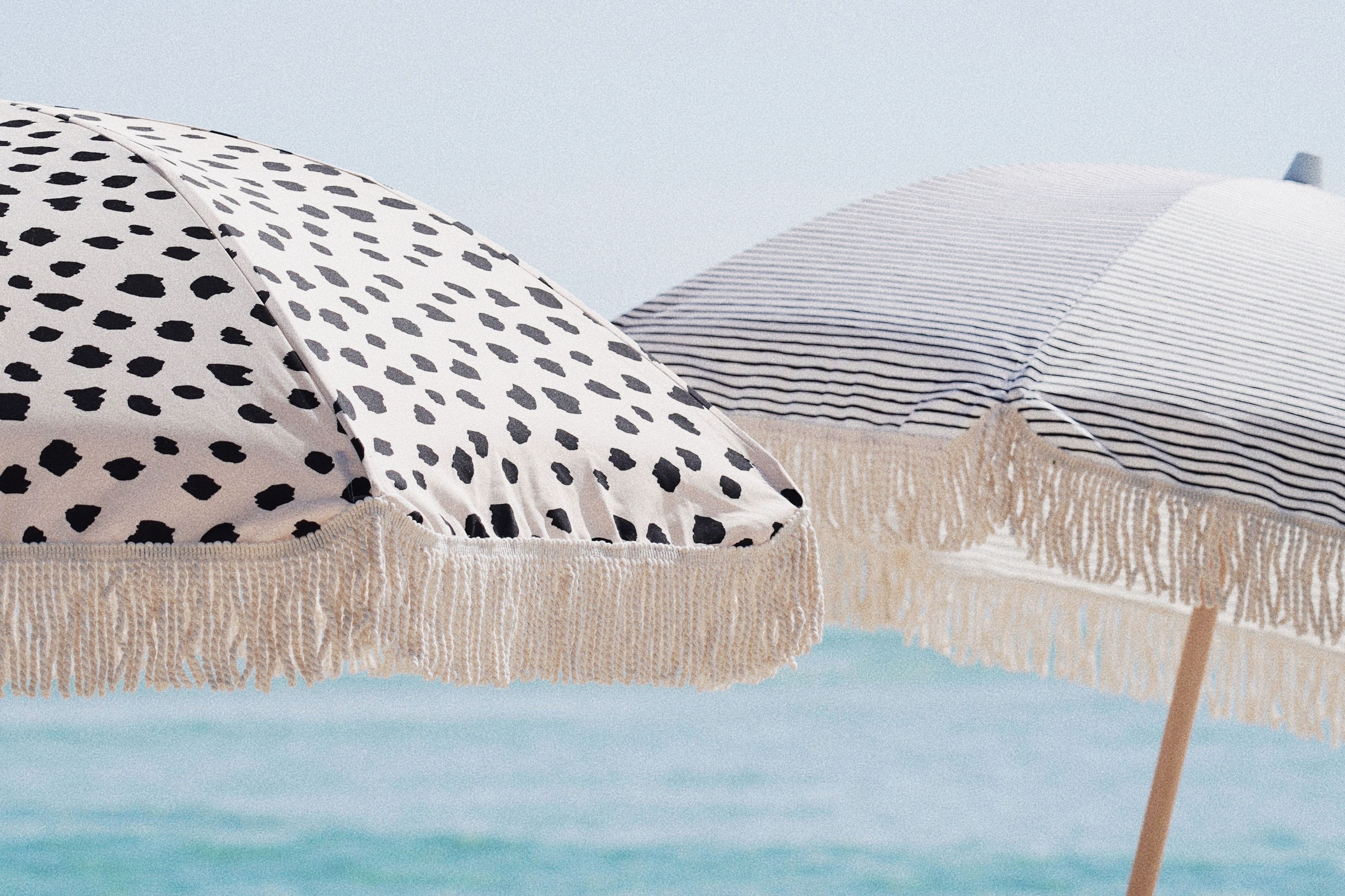 Spotted Beach Umbrella with tassels and Striped Beach Umbrella with Tassels by Sunday Supply Co. Australia