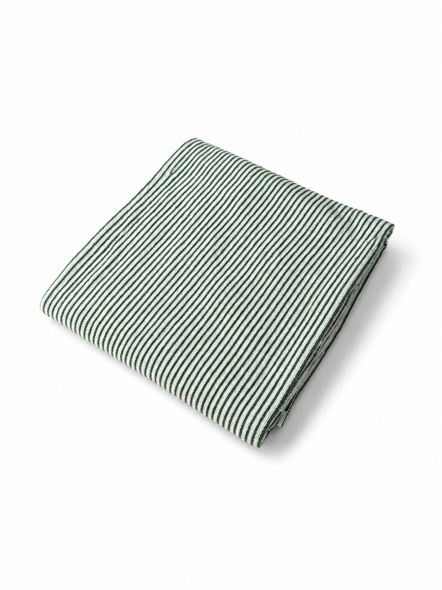 Folded Native green and white striped beach towel viewed at an angle on a white background.