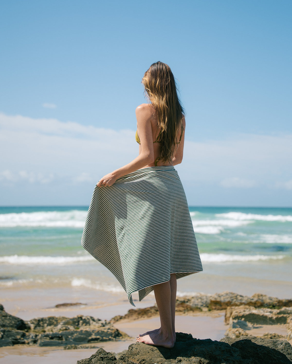 Native striped beach towel wrapped around a model at the beach.